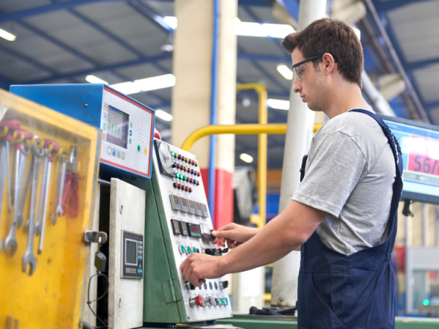 Học viên ngành vận hành máy tại Đức đang điều khiển máy CNC trong nhà xưởng hiện đại